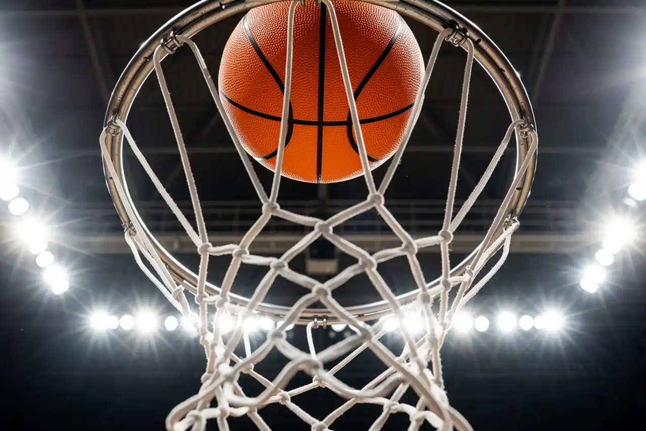 Canestro da basket visto dal basso con pallone in volo verso il ferro